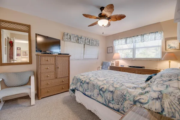 a bedroom with a large bed and a flat tv screen on dresser