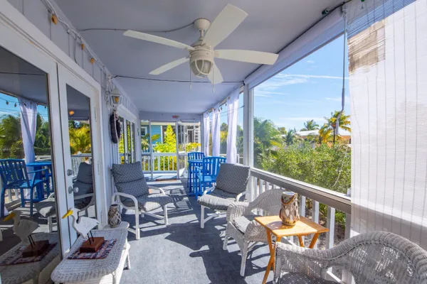 a living room with patio furniture and a large window