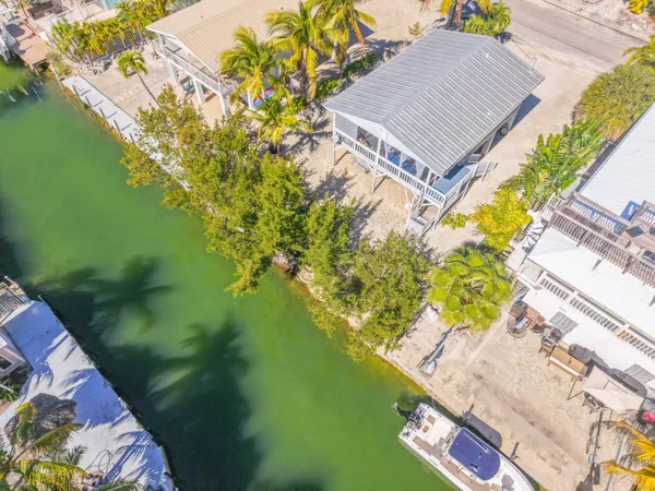 a aerial view of a house with a yard and lake view