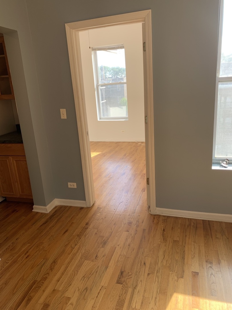 Undisclosed Address Chicago, IL 60637 - Photo 12 of 16 an empty room with wooden floor and windows