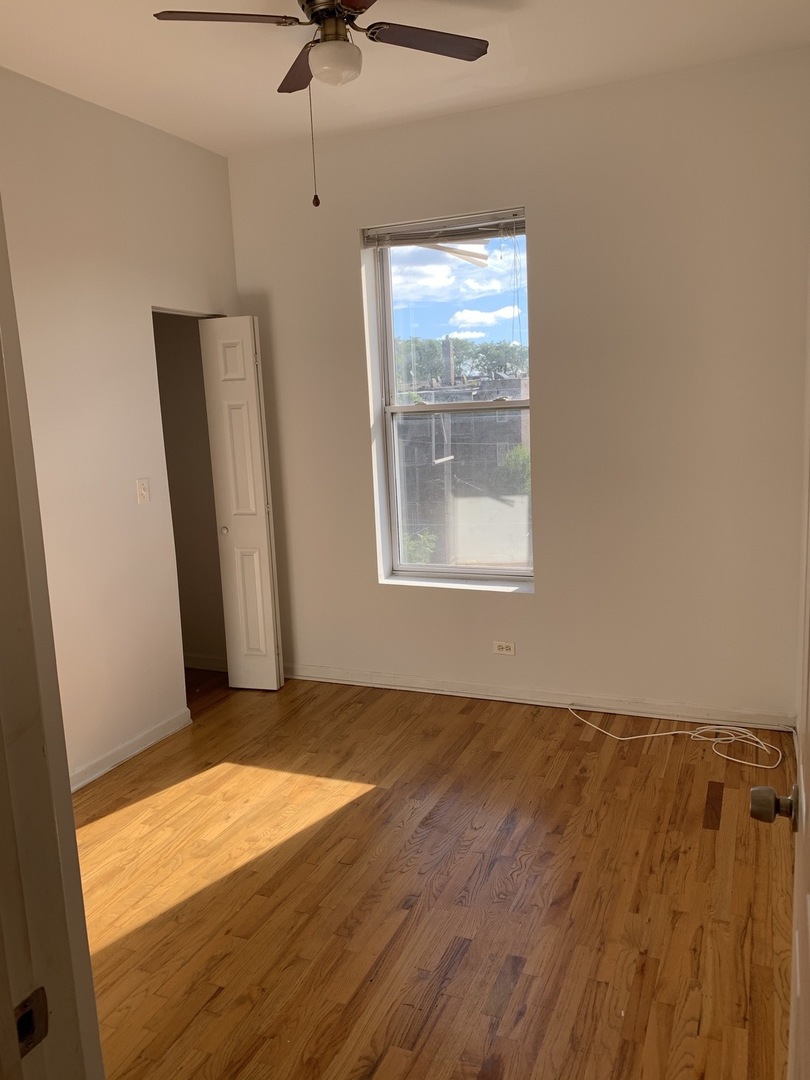 Undisclosed Address Chicago, IL 60637 - Photo 3 of 16 an empty room with wooden floor and windows