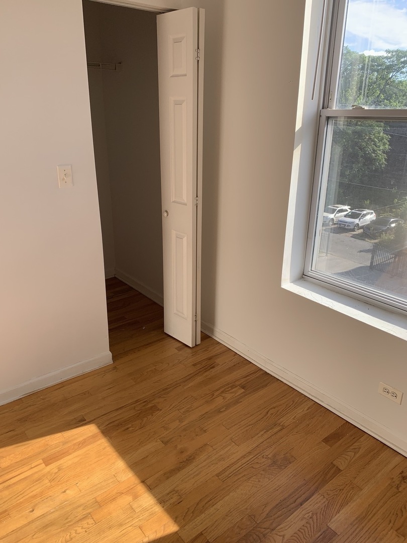 Undisclosed Address Chicago, IL 60637 - Photo 4 of 16 a view of an empty room with wooden floor and a window