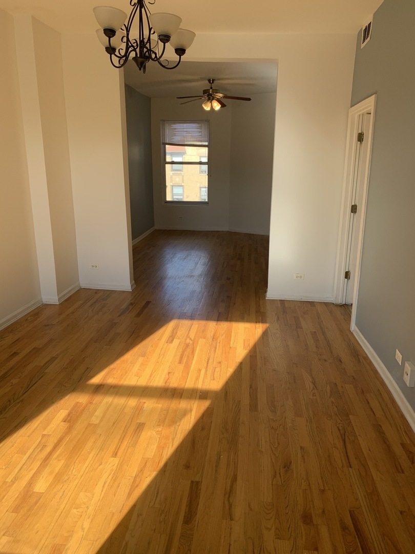 Undisclosed Address Chicago, IL 60637 - Photo 5 of 16 a view of an empty room with a window and wooden floor