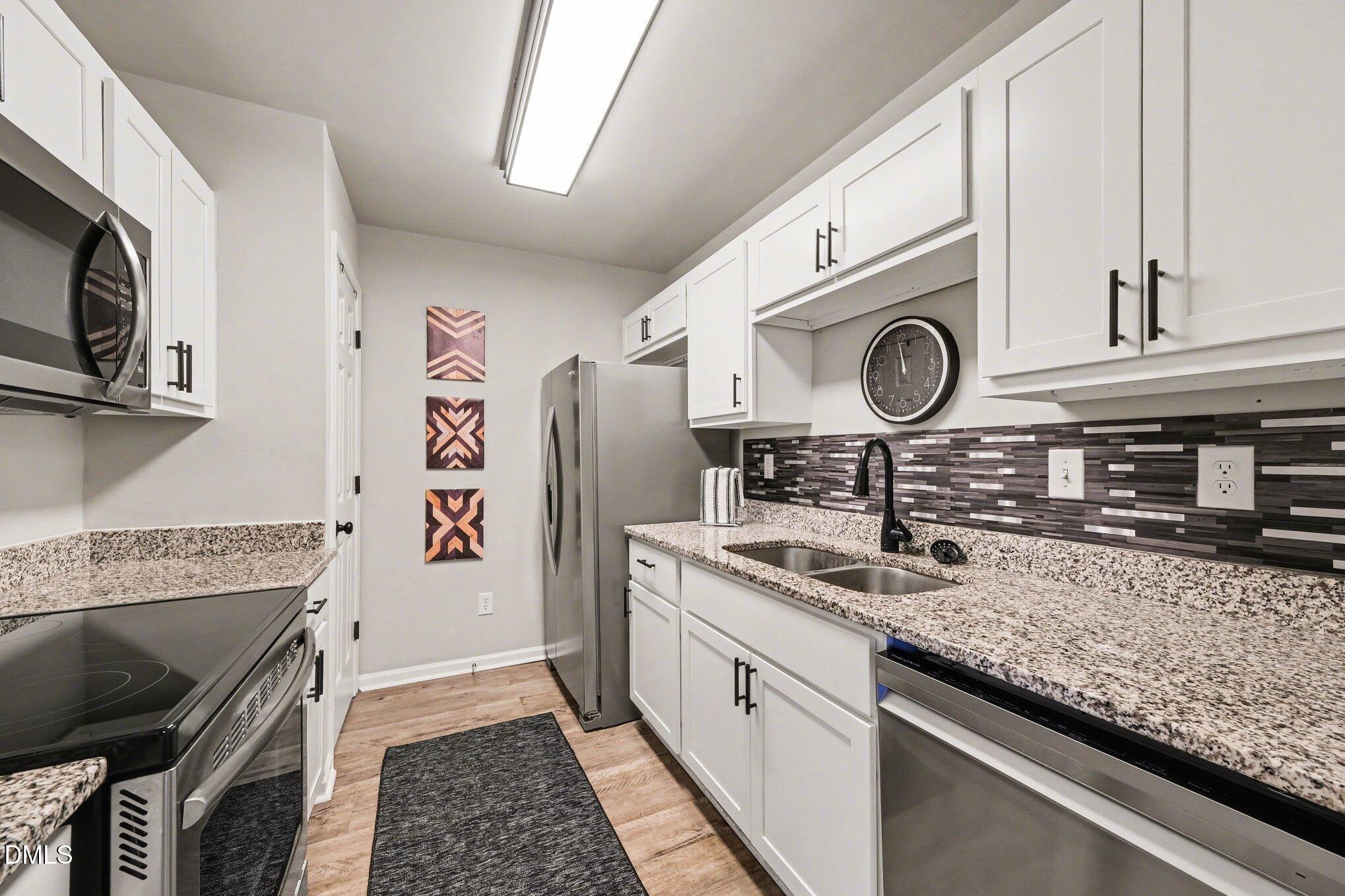702 Brye Street Durham, NC 27703 - Photo 12 of 32 a kitchen with stainless steel appliances granite countertop a sink a stove and cabinets