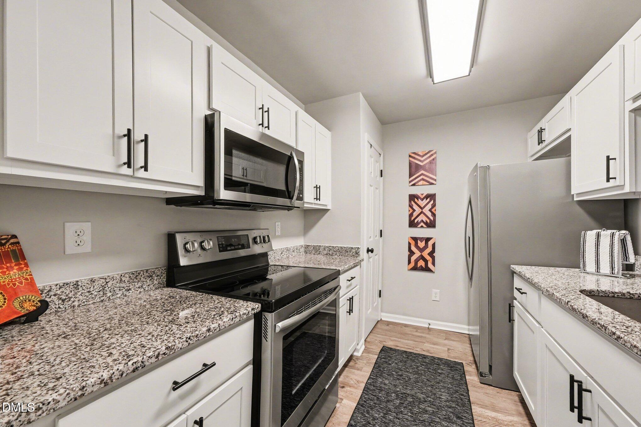 702 Brye Street Durham, NC 27703 - Photo 13 of 32 a kitchen with stainless steel appliances granite countertop a refrigerator sink and stove