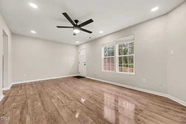 an empty room with a window and a fan