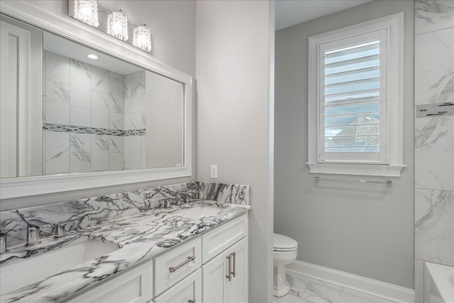 1676 Exeter Road Germantown, TN 38138 - Photo 31 of 38 a bathroom with a granite countertop sink a toilet and a mirror