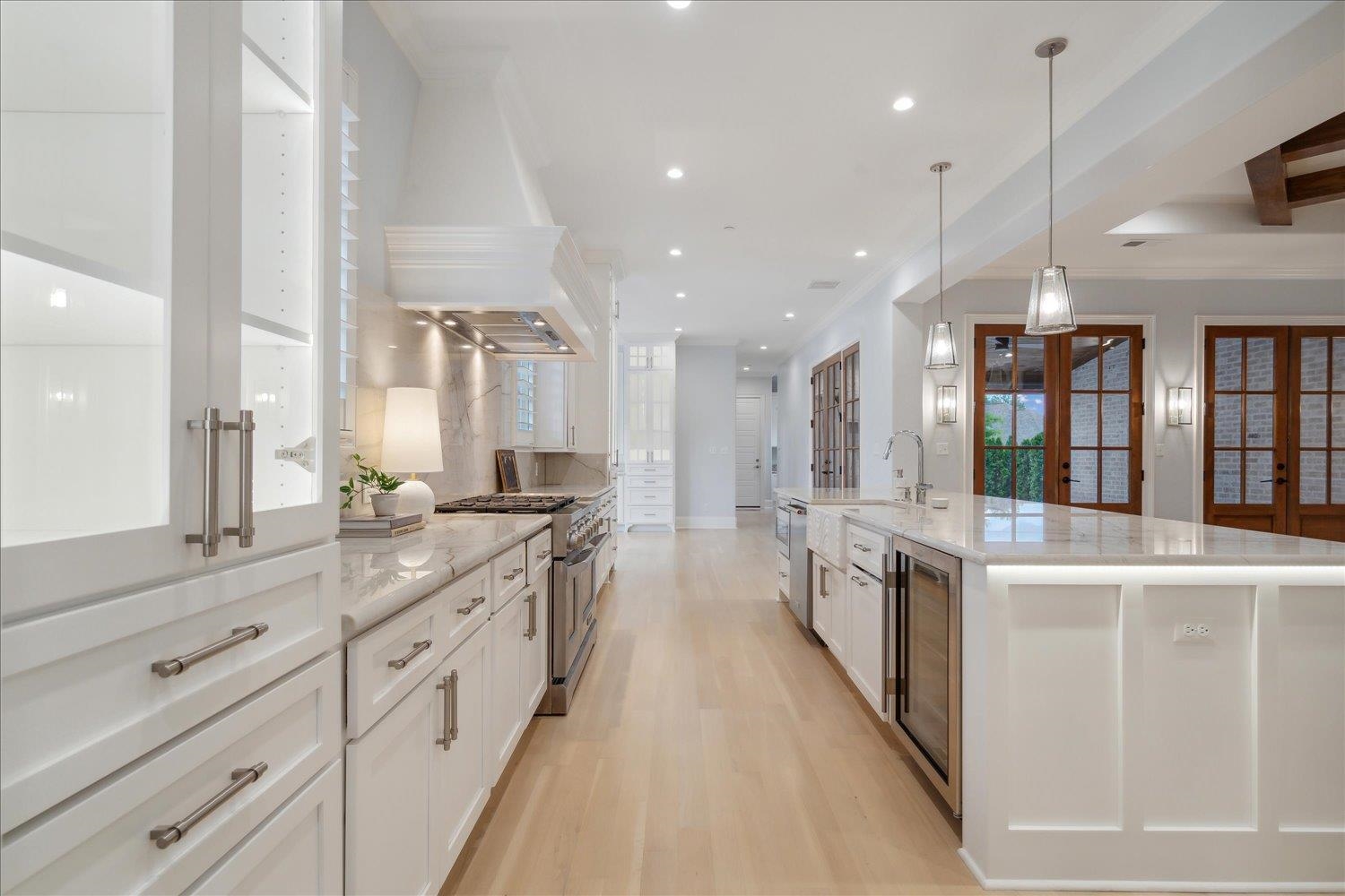 1676 Exeter Road Germantown, TN 38138 - Photo 7 of 38 a large white kitchen with lots of counter space wooden floor and stainless steel appliances