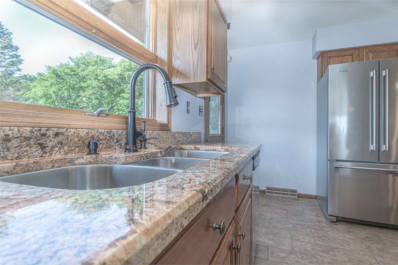 1783 West Pines Road Oregon, IL 61061 - Photo 4 of 24 a kitchen with stainless steel appliances granite countertop a sink and a refrigerator