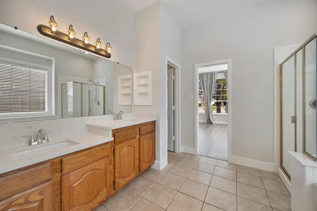a spacious bathroom with a granite countertop sink a mirror and a shower