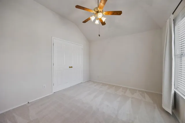 an empty room with a window and a fan