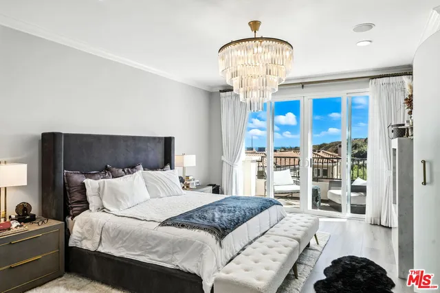 a bedroom with a large bed and a chandelier