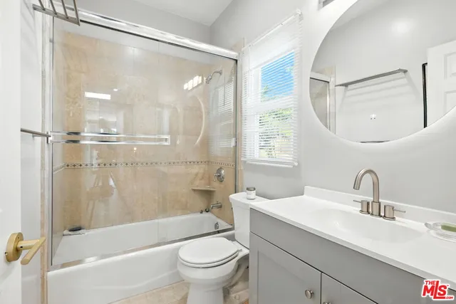 a bathroom with a sink mirror toilet and bathtub