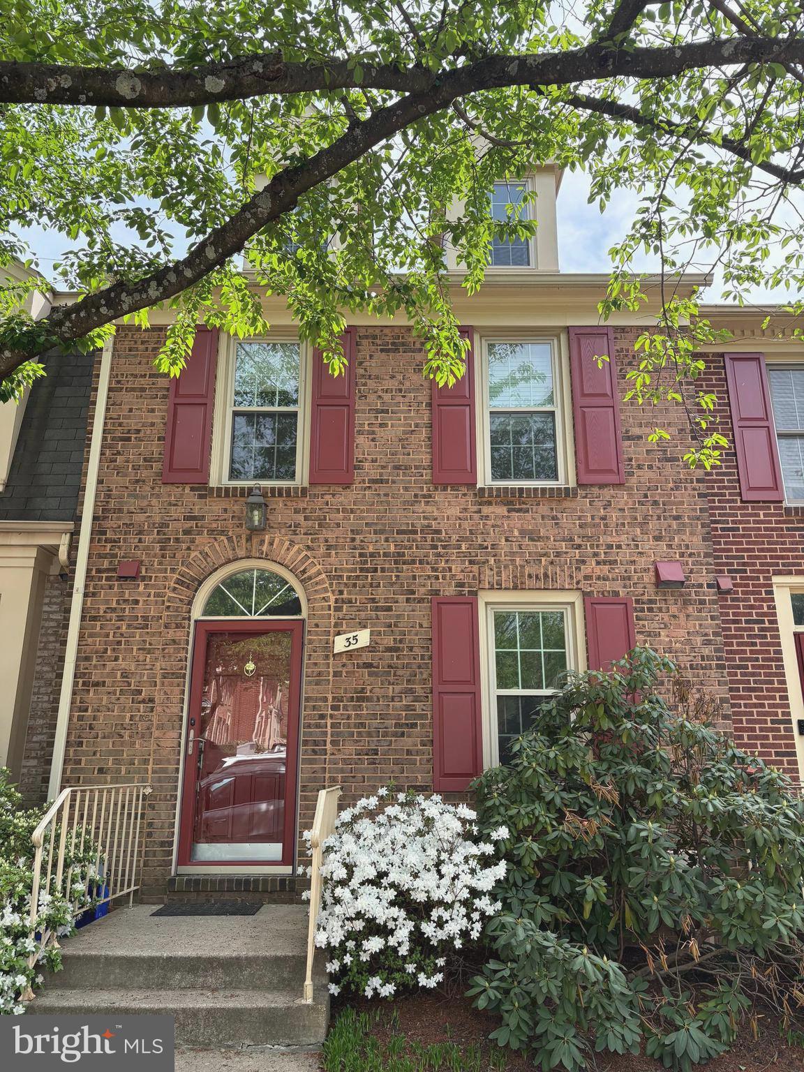 a front view of a house with a tree