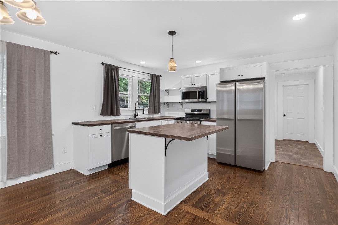 115 Pelfrey Street Seneca, SC 29672 - Photo 6 of 46 A chef's kitchen awaits with an inviting island and elegant hardwood flooring.
