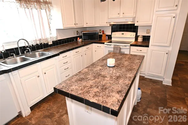 a kitchen with stainless steel appliances granite countertop a sink stove and cabinets