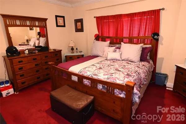 a bedroom with a bed window and a flat screen television