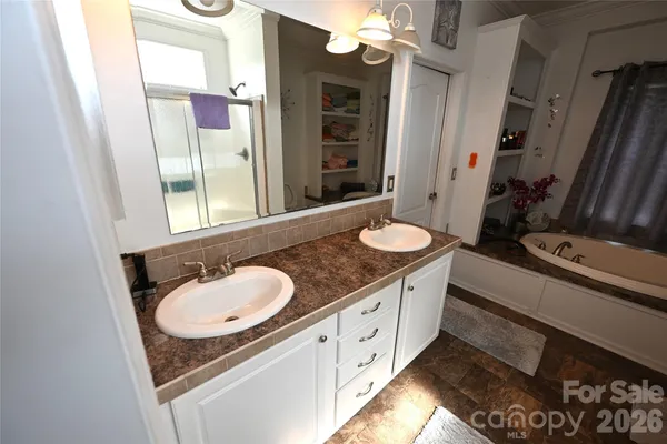 a bathroom with a granite countertop double vanity sink and a mirror