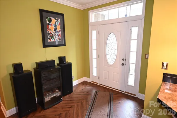 a view of a hallway with wooden floor and furniture