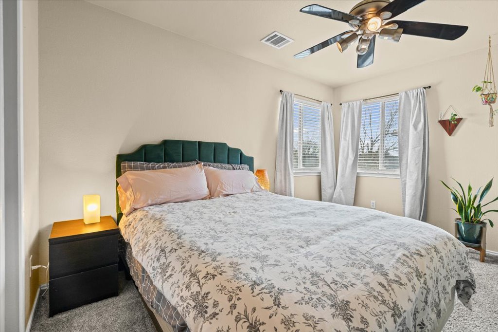 12209 Briarcreek Loop Manor, TX 78653 - Photo 13 of 23 a bedroom with a large bed and a chandelier
