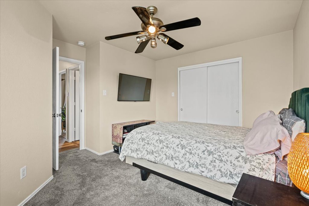 12209 Briarcreek Loop Manor, TX 78653 - Photo 14 of 23 a bedroom with a bed and a flat screen tv