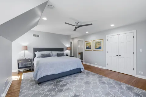 a spacious bedroom with a bed and a ceiling fan