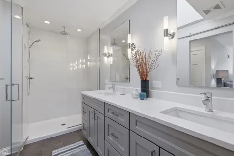 a bathroom with double vanity sink and a mirror