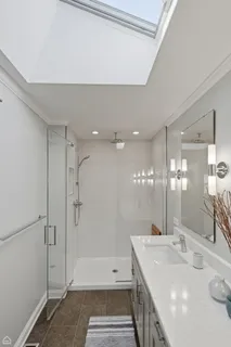 a bathroom with a double vanity sink mirror and shower