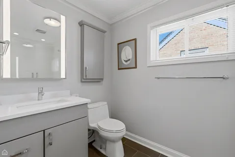 a bathroom with a toilet sink and mirror
