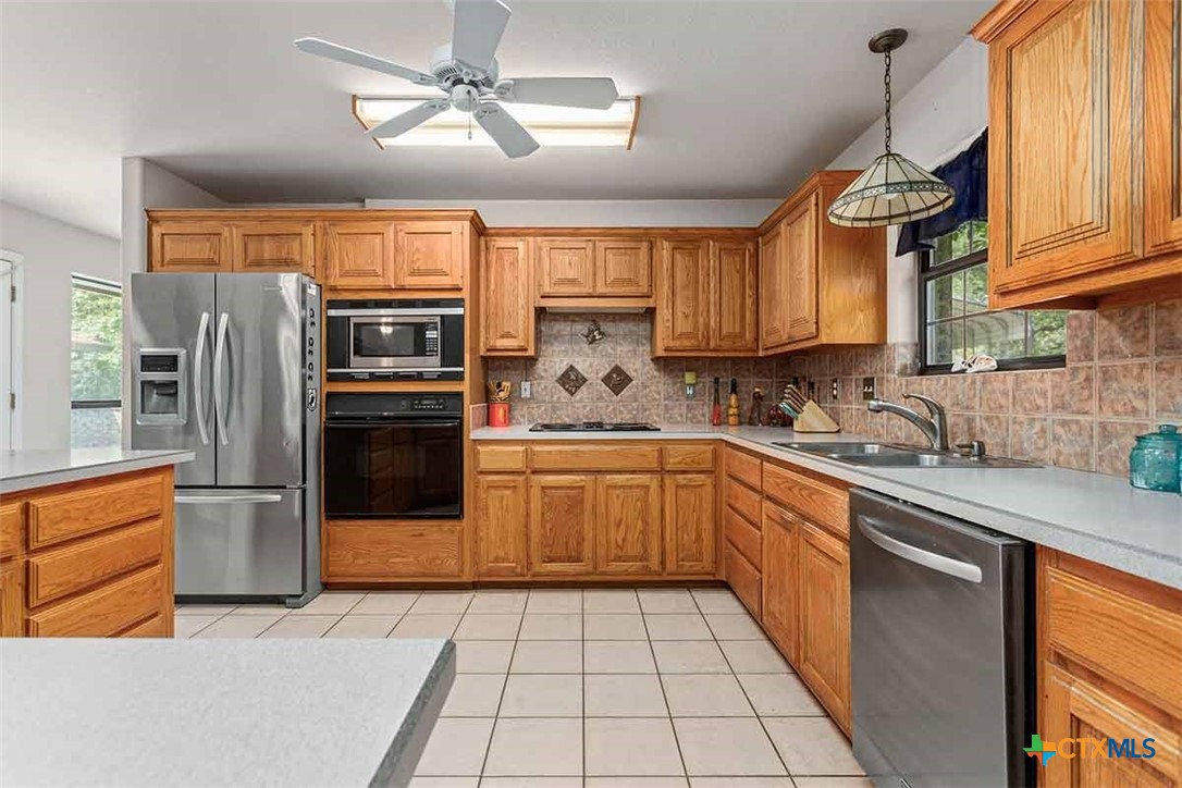 20-acres Guadalupe Ranch Lane Seguin, TX 78155 - Photo 18 of 42 a kitchen with stainless steel appliances granite countertop a refrigerator a sink dishwasher a stove and white cabinets