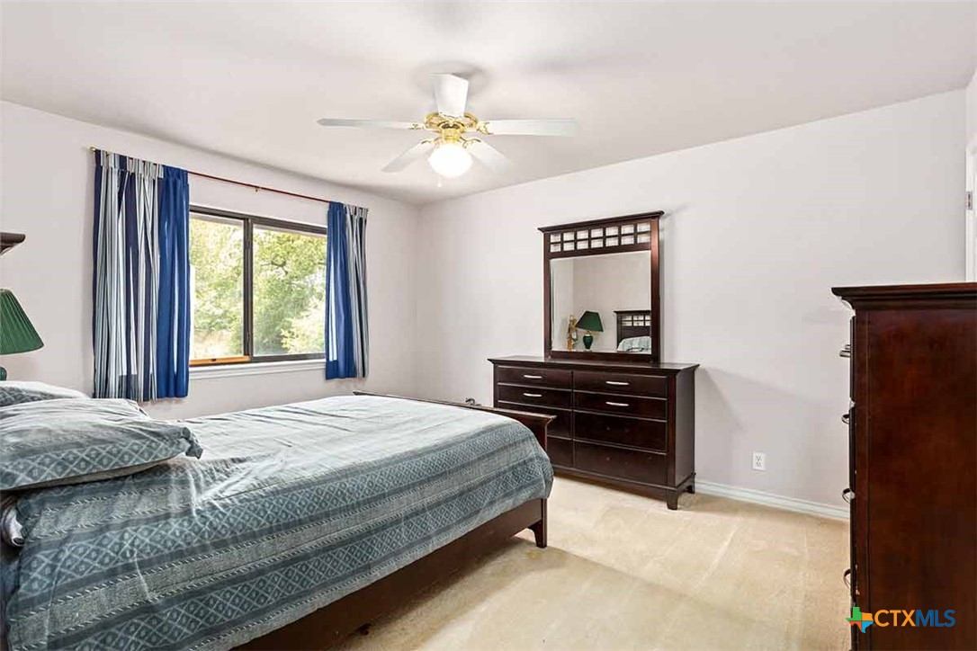20-acres Guadalupe Ranch Lane Seguin, TX 78155 - Photo 28 of 42 a bedroom with a bed and a chandelier