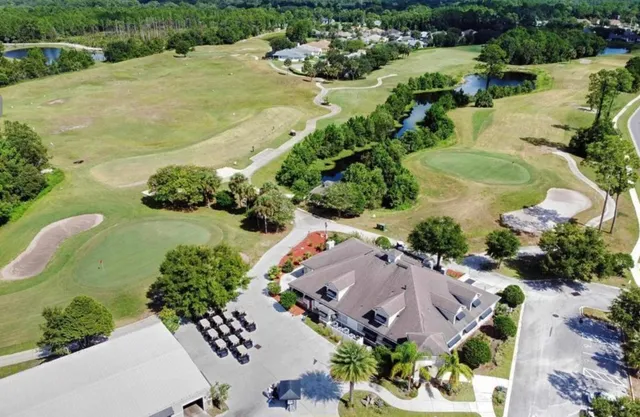 an aerial view of a house with a garden and swimming pool