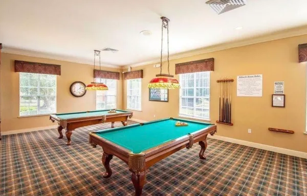 a room with pool table and windows