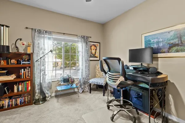 a view of a workspace with furniture and a window