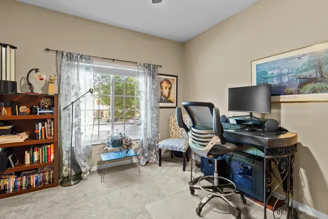 a view of a workspace with furniture and a window