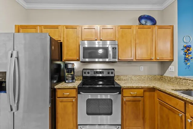 a kitchen with stainless steel appliances granite countertop a stove a sink and a microwave