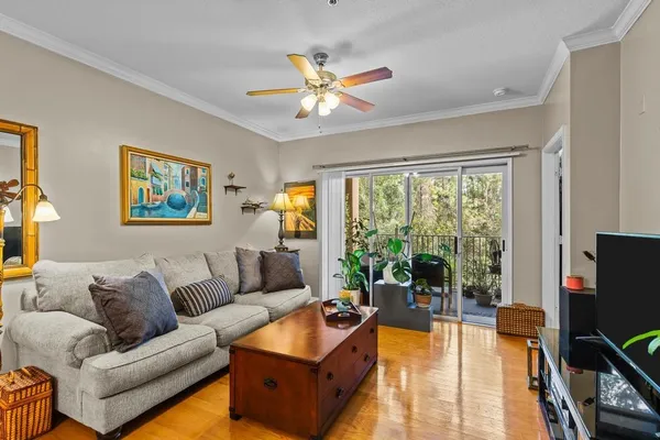 a living room with furniture floor to ceiling window and a flat screen tv