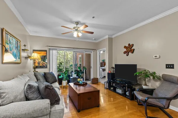 a living room with furniture a flat screen tv and a large window
