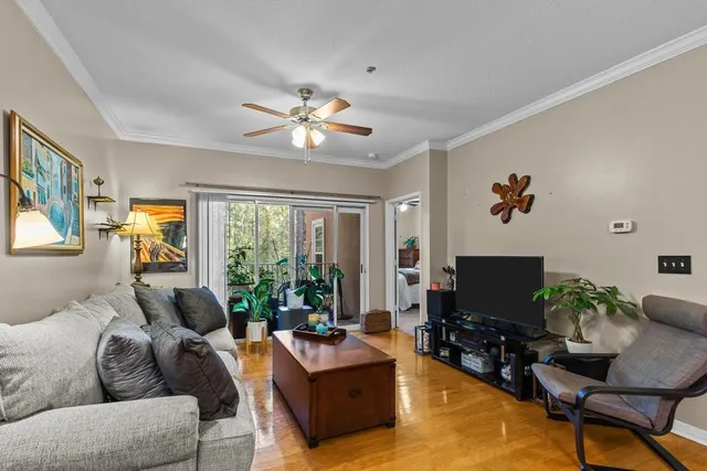 a living room with furniture a flat screen tv and a large window