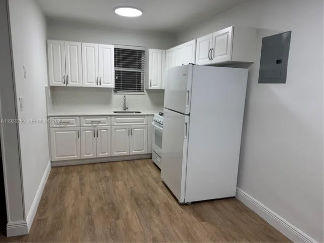 a kitchen with wooden cabinets and white appliances