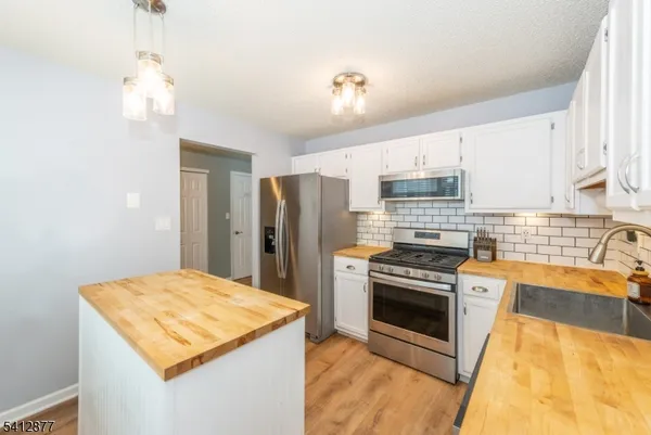 a kitchen with a stove a sink and a refrigerator