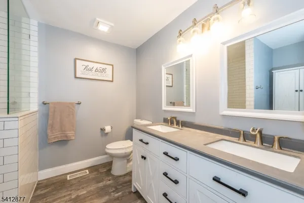 a bathroom with a granite countertop sink mirror and toilet