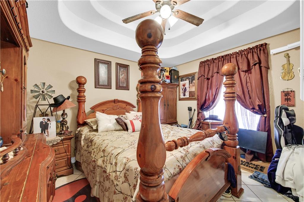 695 El Paisano Road Rio Grande City, TX 78582 - Photo 11 of 30 Bedroom featuring a raised ceiling, a ceiling fan, and tile patterned flooring
