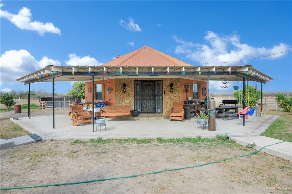 695 El Paisano Road Rio Grande City, TX 78582 - Photo 23 of 30 Rear view of house with a patio and stone siding