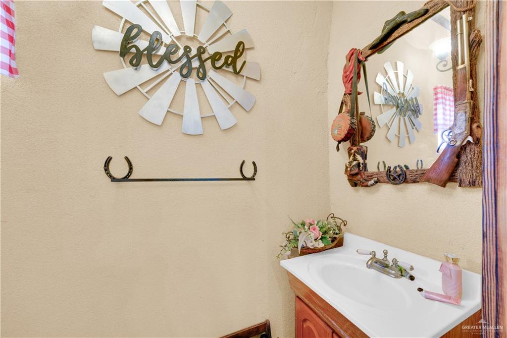 695 El Paisano Road Rio Grande City, TX 78582 - Photo 8 of 30 Bathroom featuring vanity and a textured wall