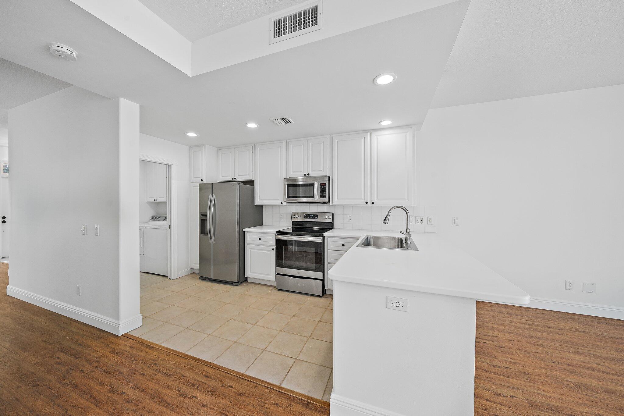 304 Legare Court Jupiter, FL 33458 - Photo 12 of 38 a kitchen with stainless steel appliances a refrigerator sink and microwave