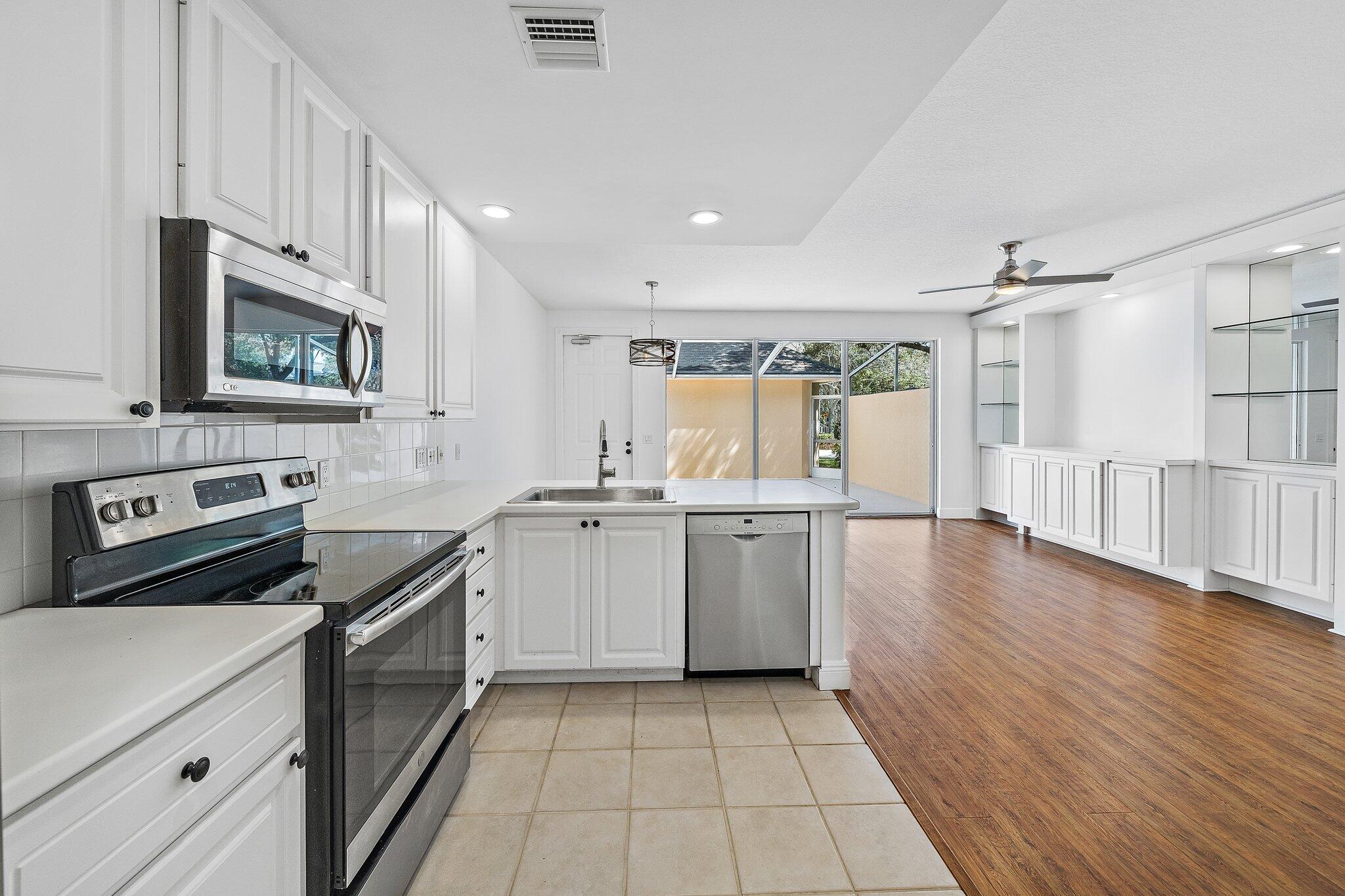 304 Legare Court Jupiter, FL 33458 - Photo 13 of 38 a kitchen with a sink stove and cabinets