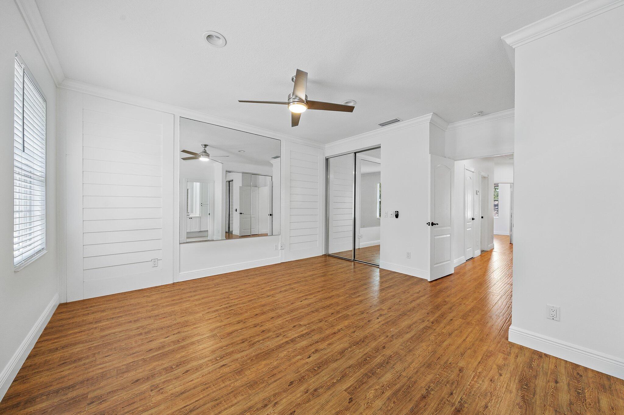 304 Legare Court Jupiter, FL 33458 - Photo 19 of 38 a view of empty room with wooden floor and fan