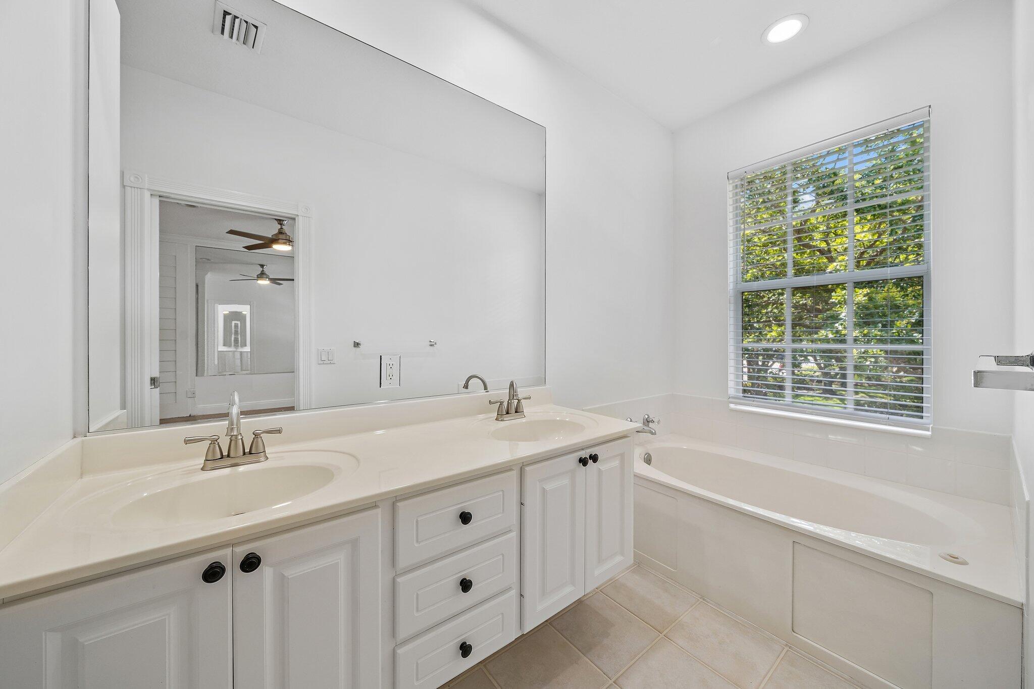 304 Legare Court Jupiter, FL 33458 - Photo 22 of 38 a bathroom with a tub a sink and mirror