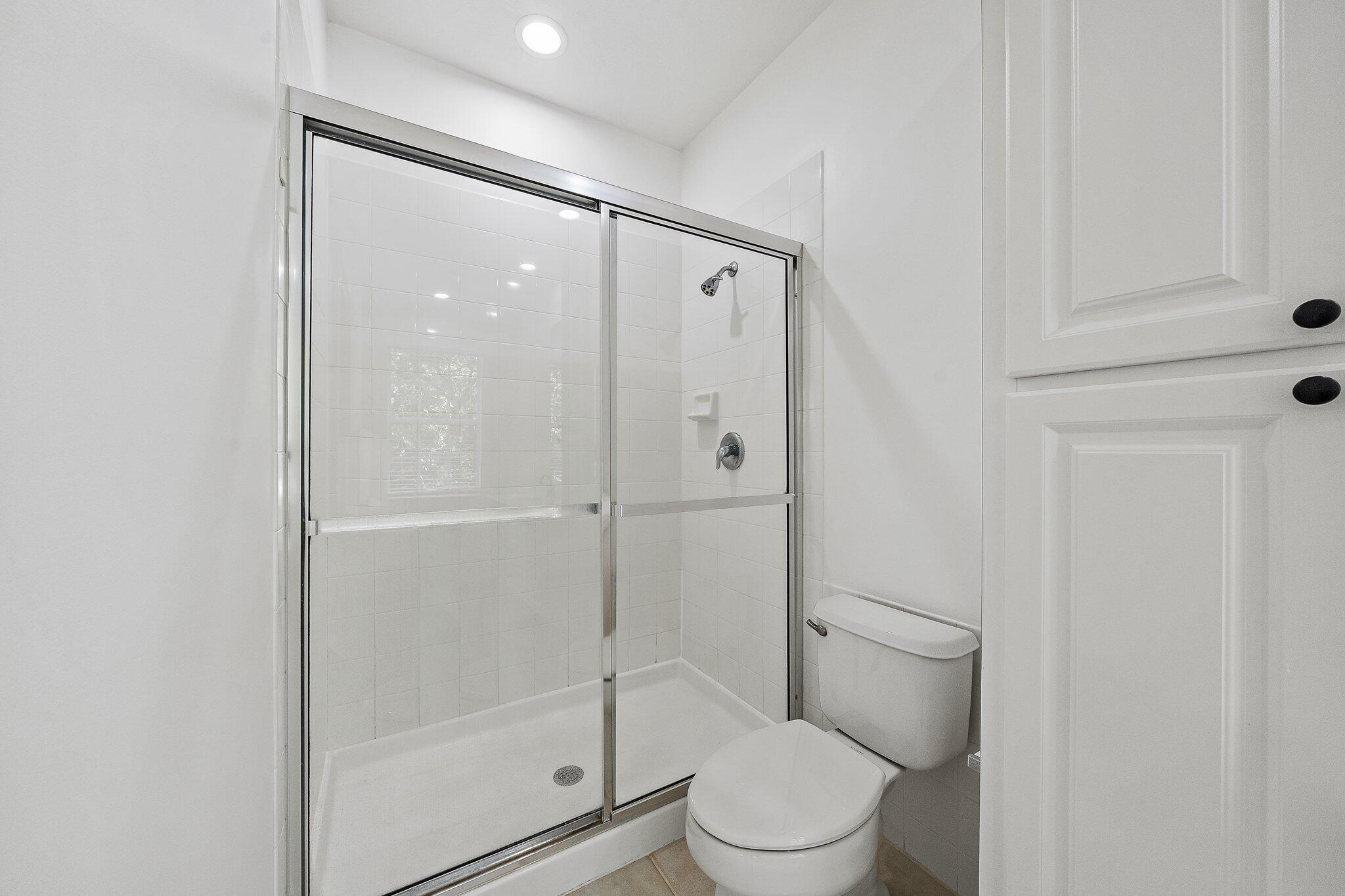 304 Legare Court Jupiter, FL 33458 - Photo 23 of 38 a bathroom with a shower a toilet and a sink